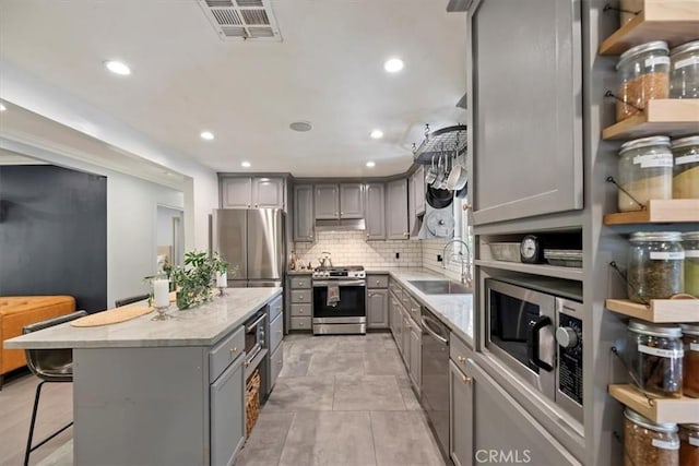 3751 Laurita Ave, Pasadena, CA 91107 - kitchen with gray cabinets, stainless steel appliances, a kitchen island, decorative backsplash, and recessed lighting