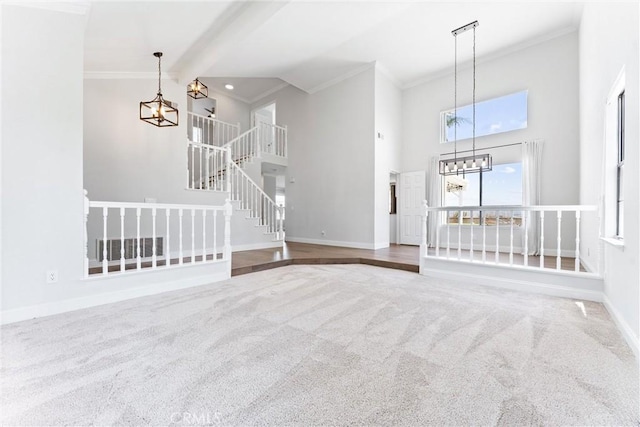 28422 La Pradera, Laguna Niguel, CA 92677 - unfurnished living room featuring a chandelier, carpet, ornamental molding, a towering ceiling, and stairs