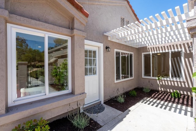 1481 Camino Linda Dr, San Marcos, CA 92078 - view of exterior entry with a patio, stucco siding, and a pergola