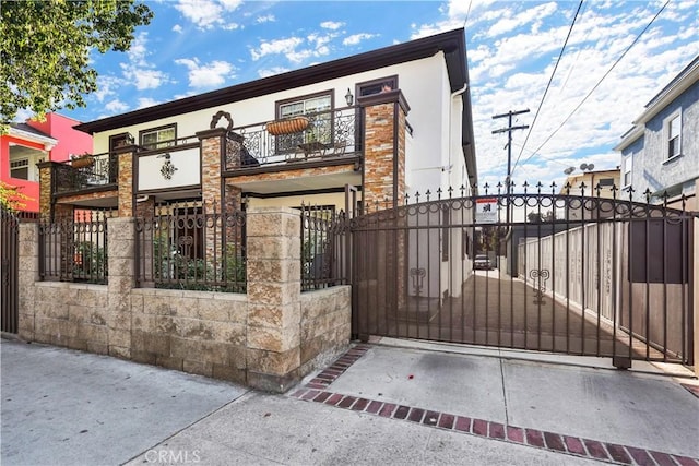 56665672 Franklin Ave, Los Angeles, CA 90028 - view of front facade featuring a balcony, a fenced front yard, a gate, and stucco siding