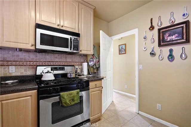 56665672 Franklin Ave, Los Angeles, CA 90028 - kitchen with stainless steel gas range, dark countertops, light tile patterned floors, and backsplash