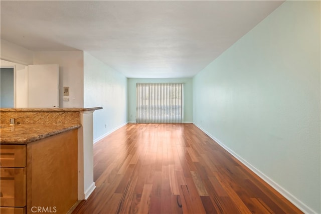5585 E Pacific Coast Unit 144, Long Beach, CA 90804 - unfurnished living room featuring wood finished floors and baseboards