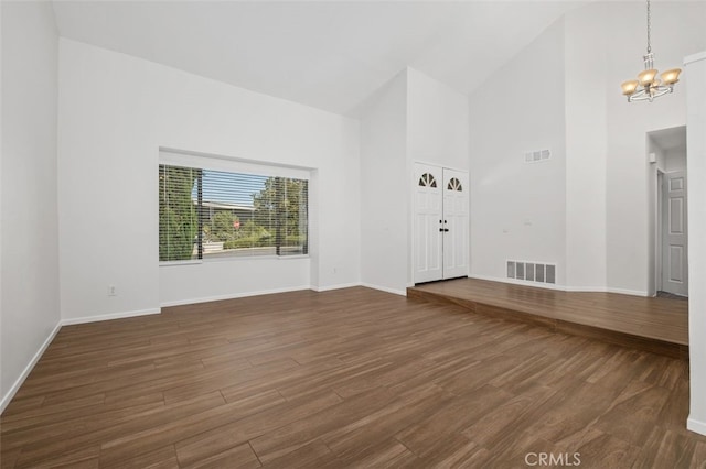 28611 Avenida Del Caballo, Laguna Niguel, CA 92677 - unfurnished living room with high vaulted ceiling, a chandelier, and dark wood-style flooring