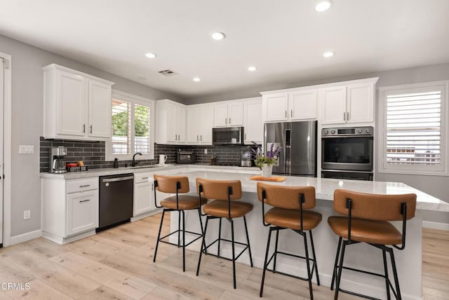 5091 Via Fresco, Camarillo, CA 93012 - kitchen with stainless steel appliances, light wood-type flooring, white cabinetry, tasteful backsplash, and recessed lighting
