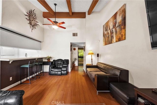2700 Cahuenga Blvd E Unit 1302, Los Angeles, CA 90068 - living area with beamed ceiling, a high ceiling, a ceiling fan, and wood finished floors
