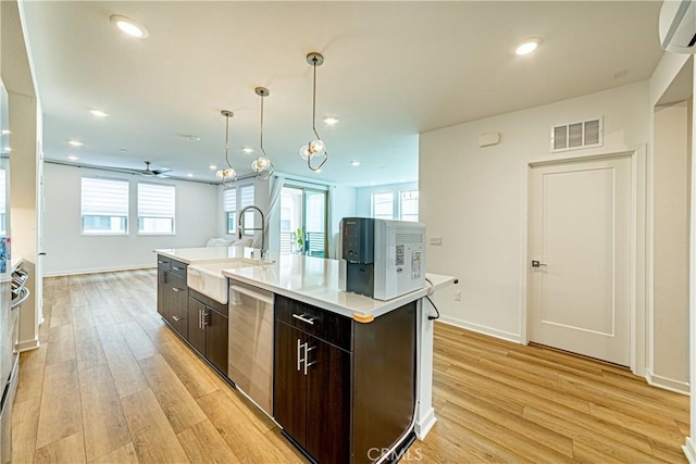 275 Pin Ln, Covina, CA 91722 - kitchen with dishwasher, an AC wall unit, light wood-type flooring, dark brown cabinets, and light countertops