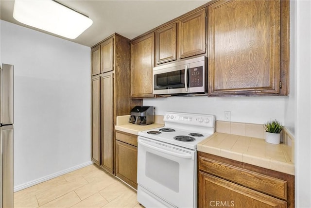 4170 Elm Ave Unit 304, Long Beach, CA 90807 - kitchen featuring stainless steel appliances, tile countertops, and brown cabinets