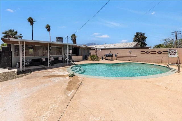 66890 Hacienda Ave, Desert Hot Springs, CA 92240 - view of swimming pool with a sunroom, a patio area, a fenced backyard, and grilling area