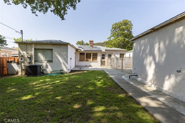 2046 E Glenoaks Blvd, Glendale, CA 91206 - back of house with solar panels, a fenced backyard, a chimney, stucco siding, and a patio area