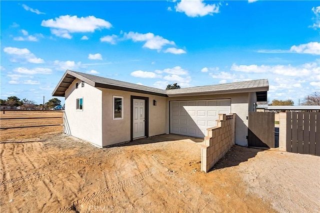 41331 20th St W, Palmdale, CA 93551 - rear view of property with stucco siding, a garage, driveway, and a gate