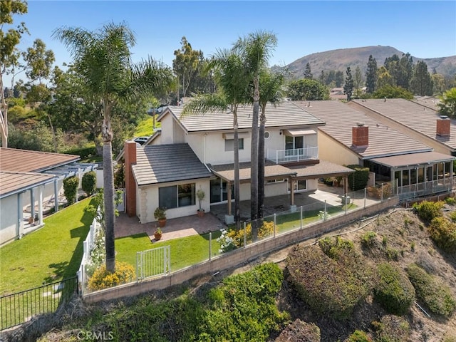 7012 E Viewpoint Ln, Anaheim Hills, CA 92807 - back of house featuring stucco siding, a mountain view, a balcony, and a fenced backyard