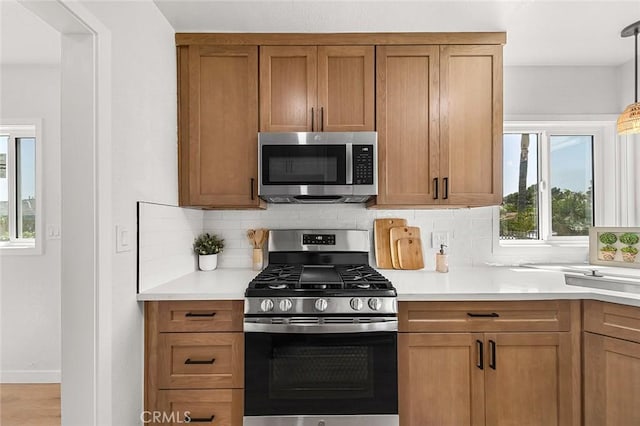 1021 W 5th St, Corona, CA 92882 - kitchen with stainless steel appliances, backsplash, and brown cabinetry