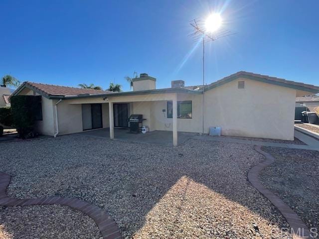 1003 Amherst Ave, Hemet, CA 92544 - rear view of property featuring a chimney, stucco siding, and a patio