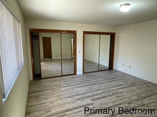 1003 Amherst Ave, Hemet, CA 92544 - unfurnished bedroom with multiple closets and wood finished floors