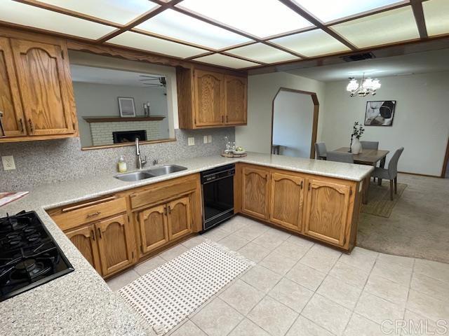 1003 Amherst Ave, Hemet, CA 92544 - kitchen with black appliances, light countertops, a peninsula, and brown cabinetry