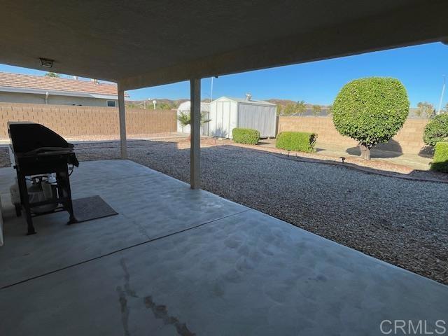 1003 Amherst Ave, Hemet, CA 92544 - fenced backyard featuring a storage unit and a patio area