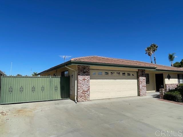 1003 Amherst Ave, Hemet, CA 92544 - ranch-style house featuring brick siding, an attached garage, and driveway