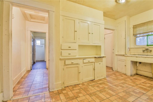 1615 W 39th Pl, Los Angeles, CA 90062 - kitchen with brick patterned flooring, plenty of natural light, and light countertops