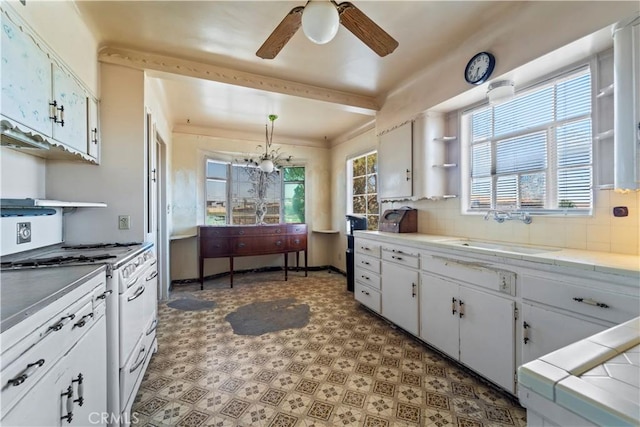 100 E Buena Vista St, Barstow, CA 92311 - kitchen featuring open shelves, light flooring, ceiling fan, backsplash, and white cabinets