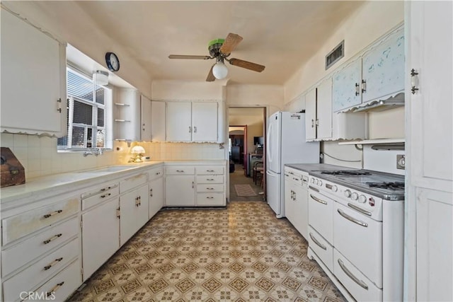 100 E Buena Vista St, Barstow, CA 92311 - kitchen with white cabinets, white appliances, ceiling fan, tasteful backsplash, and light floors