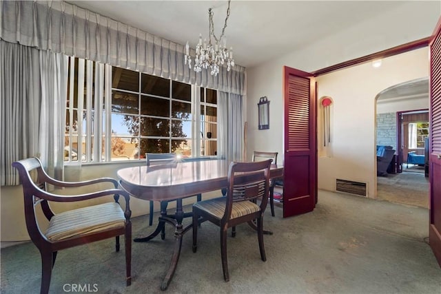 100 E Buena Vista St, Barstow, CA 92311 - dining area featuring carpet, arched walkways, and a chandelier