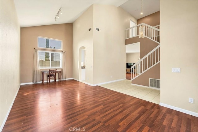 44601 Jamin Cir, Temecula, CA 92592 - unfurnished living room with wood finished floors, stairway, high vaulted ceiling, and arched walkways