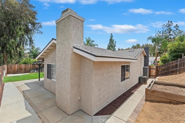 2266 Mcneil Cir, Corona, CA 92882 - view of side of property featuring stucco siding, a fenced backyard, a chimney, and a patio area