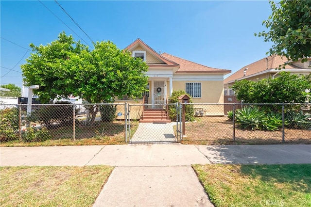 1203 E 33rd St, Los Angeles, CA 90011 - view of front of home with a gate, a fenced front yard, and stucco siding