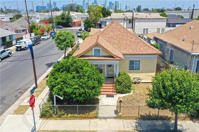1203 E 33rd St, Los Angeles, CA 90011 - view of front facade featuring a shingled roof, stucco siding, a fenced front yard, a gate, and a residential view
