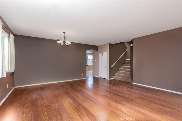 25540 Riley Cir, Menifee, CA 92585 - unfurnished living room featuring arched walkways, plenty of natural light, a chandelier, and stairs
