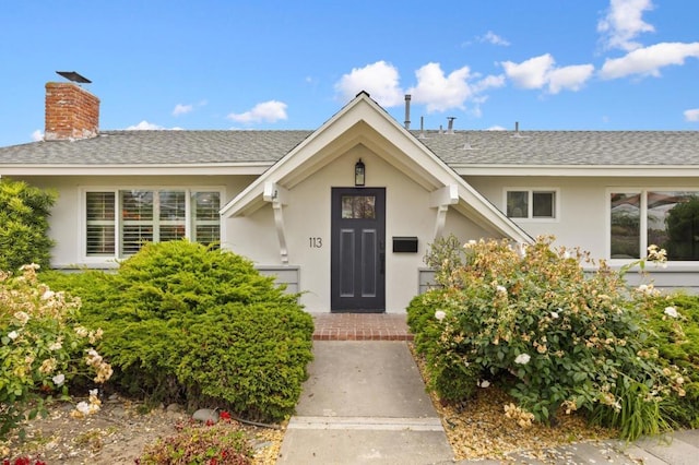 113 Via Breve Unit 23, San Clemente, CA 92672 - doorway to property featuring stucco siding, a shingled roof, and a chimney