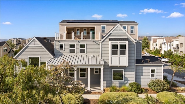 125 Character, Irvine, CA 92618 - rear view of house with a balcony, a residential view, solar panels, and a standing seam roof