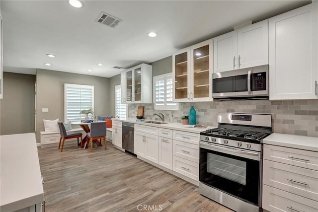 4437 Keever Ave, Long Beach, CA 90807 - kitchen with appliances with stainless steel finishes, white cabinetry, light countertops, decorative backsplash, and recessed lighting