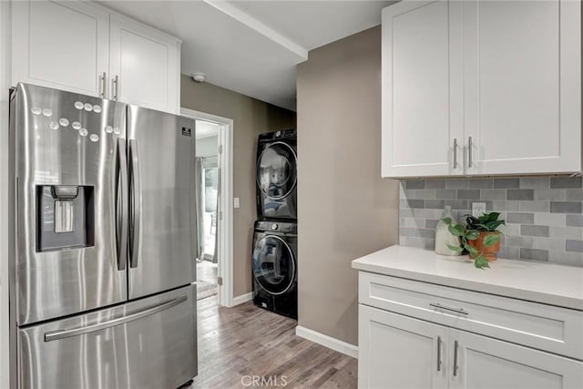 4437 Keever Ave, Long Beach, CA 90807 - kitchen featuring stainless steel fridge, stacked washer / dryer, light countertops, light wood finished floors, and white cabinetry