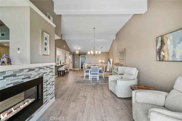 24532 Moonfire Dr, Dana Point, CA 92629 - living area with wood finished floors, a stone fireplace, and a chandelier