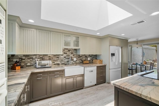 24532 Moonfire Dr, Dana Point, CA 92629 - kitchen with white appliances, tasteful backsplash, light wood-style floors, recessed lighting, and cream cabinetry