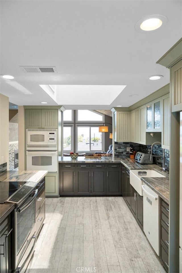 24532 Moonfire Dr, Dana Point, CA 92629 - kitchen with white appliances, light wood-style flooring, tasteful backsplash, and dark stone counters