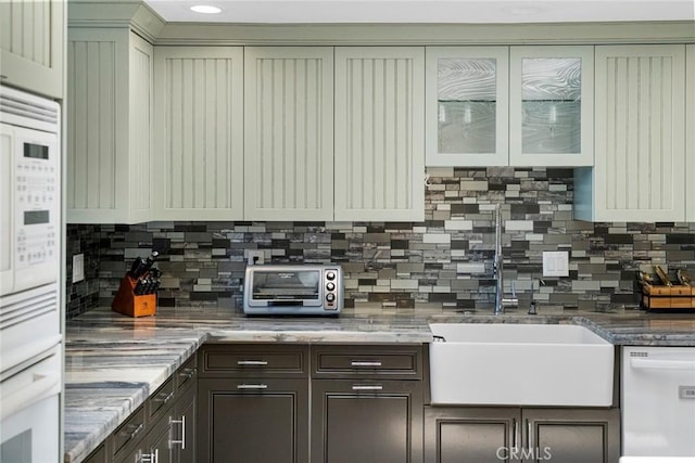 24532 Moonfire Dr, Dana Point, CA 92629 - kitchen with white appliances, backsplash, glass insert cabinets, and dark brown cabinets