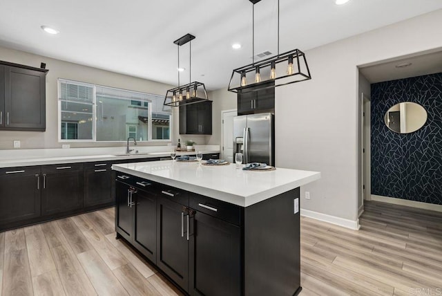 3510 Brody Way, Oceanside, CA 92056 - kitchen with stainless steel fridge with ice dispenser, dark cabinets, light wood finished floors, light countertops, and recessed lighting