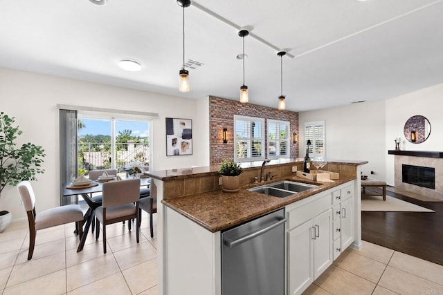 1412 Long View Dr, Chula Vista, CA 91915 - kitchen with stainless steel dishwasher, an island with sink, light tile patterned floors, white cabinets, and decorative light fixtures