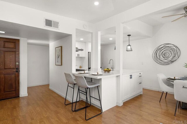 1802 Via Las Palmas Unit 36, National City, CA 91950 - kitchen featuring white cabinetry, a breakfast bar area, light countertops, light wood-style floors, and recessed lighting