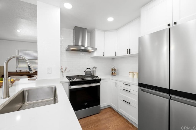 1802 Via Las Palmas Unit 36, National City, CA 91950 - kitchen with appliances with stainless steel finishes, wall chimney range hood, light countertops, tasteful backsplash, and white cabinetry