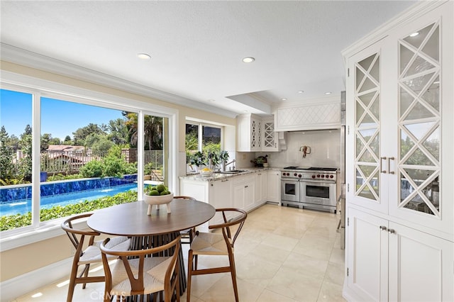 26582 Maside, Mission Viejo, CA 92692 - kitchen featuring range with two ovens, ornamental molding, light stone countertops, white cabinetry, and recessed lighting