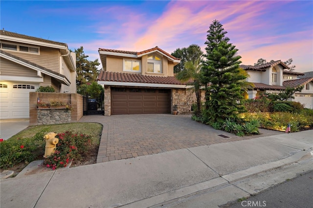 26582 Maside, Mission Viejo, CA 92692 - view of front of home with stone siding, driveway, an attached garage, stucco siding, and a tile roof