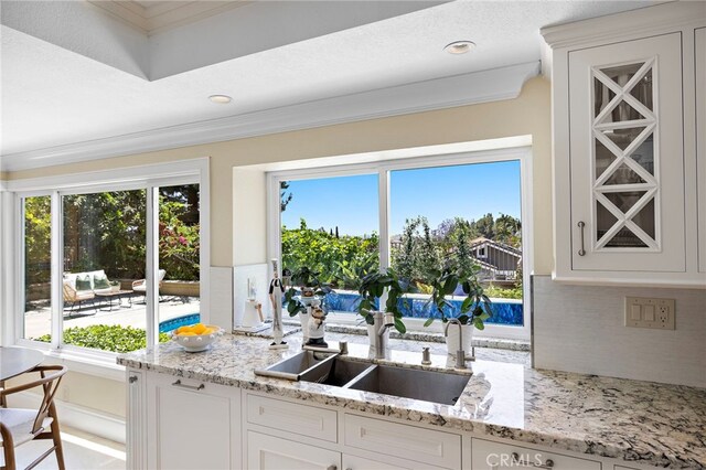 26582 Maside, Mission Viejo, CA 92692 - kitchen featuring ornamental molding, backsplash, white cabinets, and light stone counters