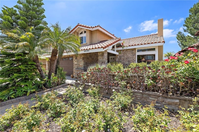 26582 Maside, Mission Viejo, CA 92692 - mediterranean / spanish home with stone siding, a tiled roof, stucco siding, a chimney, and an attached garage