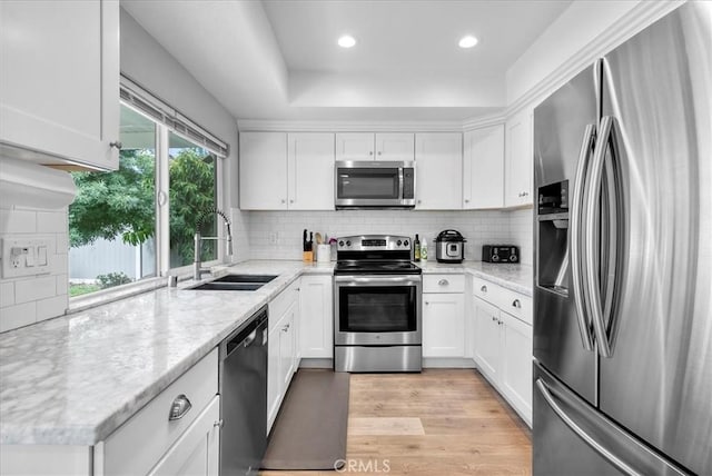 1380 Le Conte, Riverside, CA 92507 - kitchen with appliances with stainless steel finishes, white cabinets, decorative backsplash, recessed lighting, and light wood-style flooring