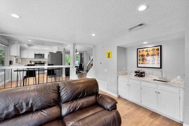 1380 Le Conte, Riverside, CA 92507 - living room featuring recessed lighting, light wood-style floors, a textured ceiling, and stairs
