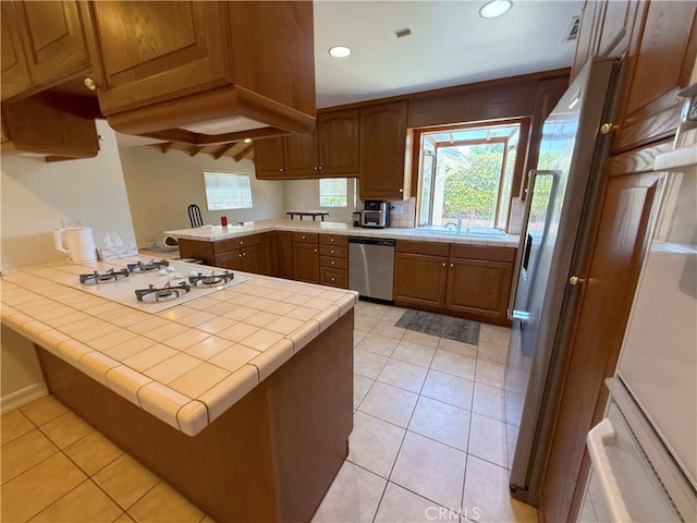 21045 Hemmingway St, Canoga Park, CA 91304 - kitchen with stainless steel dishwasher, a peninsula, tile countertops, white gas cooktop, and recessed lighting