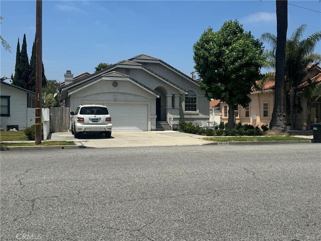 15727 Virginia Ave, Paramount, CA 90723 - view of front facade featuring an attached garage, concrete driveway, and stucco siding